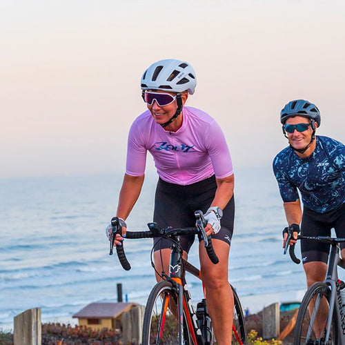 Deux cyclistes sur route en bord de mer avec le casque connecté Sena C1