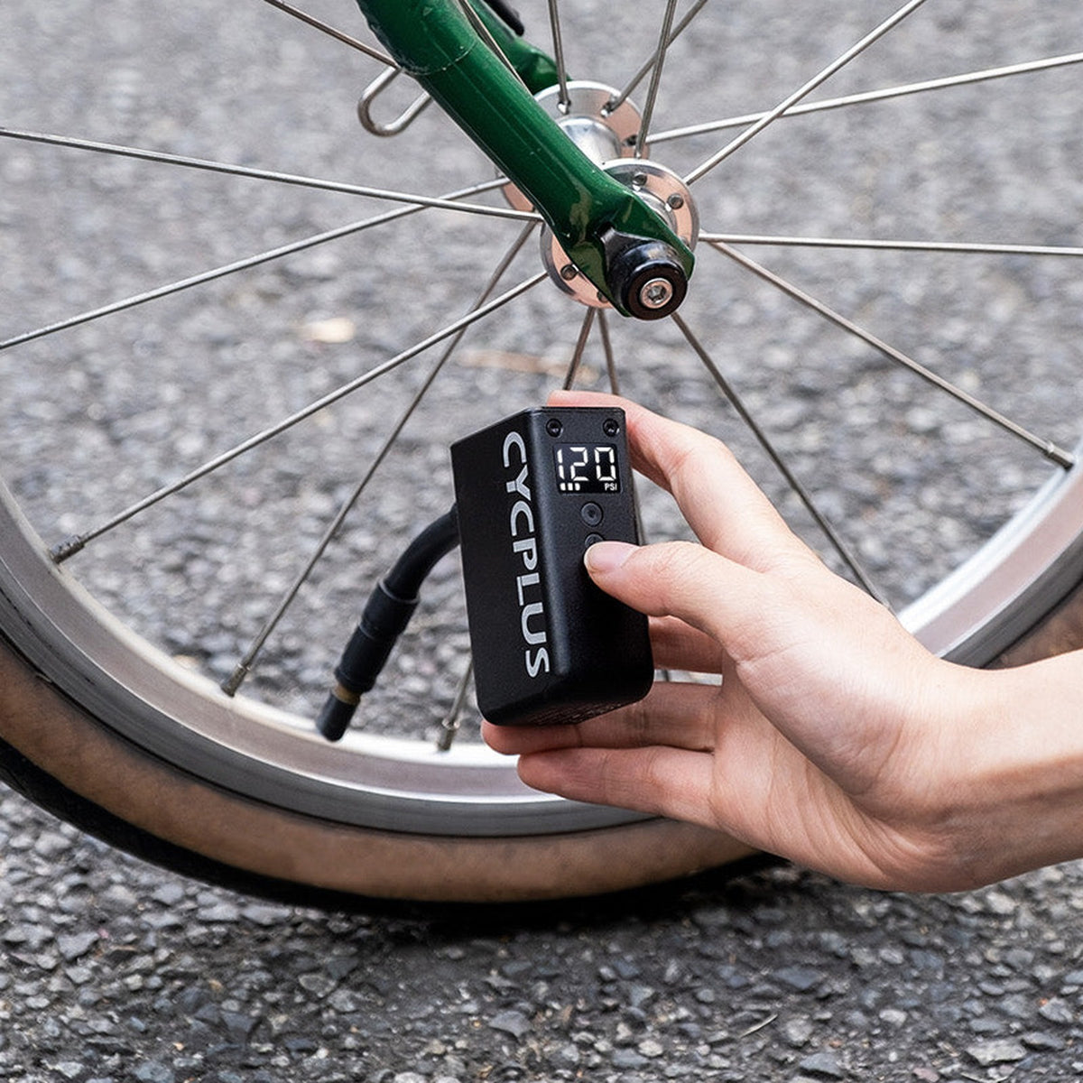 Mini pompe électrique CYCPLUS AS2 Pro gonflant la roue d'un vélo en ville