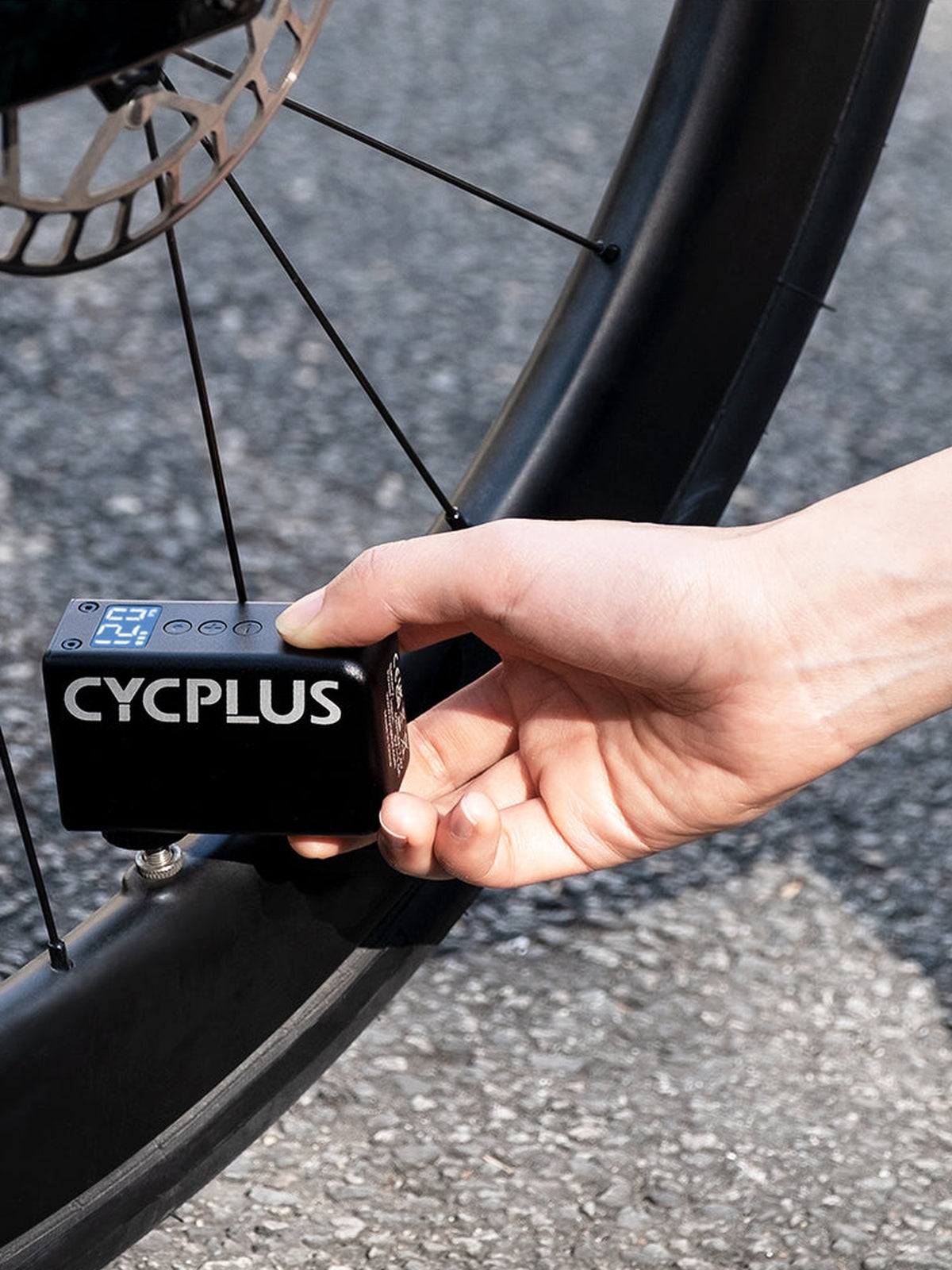 Mini pompe électrique CYCPLUS AS2 Pro branchée sur la valve d'une roue de vélo