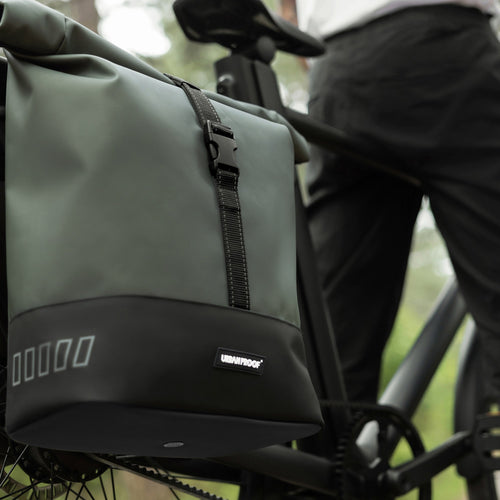 Double sacoche RollTop Urban Proof verte portée sur le porte-bagages d'un vélo
