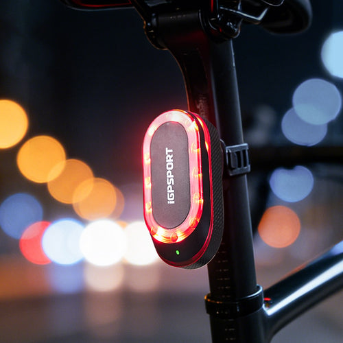 Feu arrière radar iGPSPORT SR mini allumé sur une tige de selle en ville, de nuit