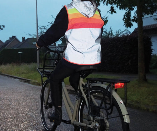 Gilet réfléchissant GOFLUO Darkflow porté à vélo en ville à la tombée de la nuit