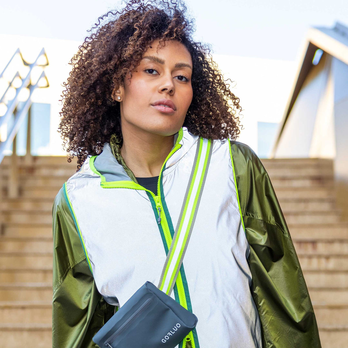 Gilet réfléchissant GOFLUO DarkNight porté avec un sac bandoulière en ville