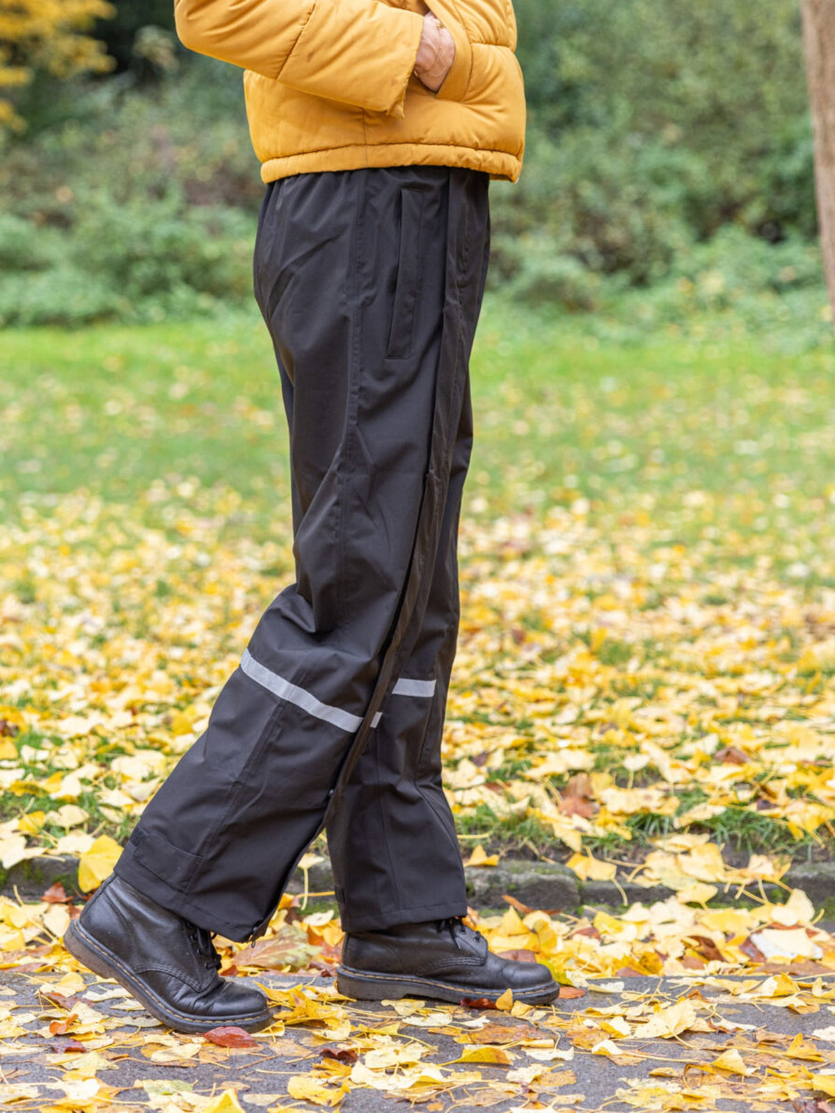 Pantalon de pluie Hello Rain noir porté dans un parc en automne