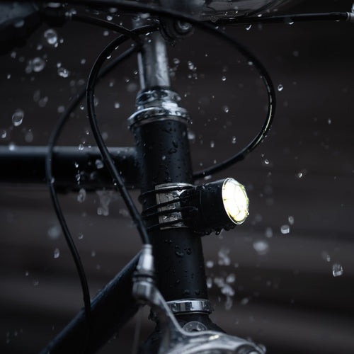 Mini lumière avant magnétique Shapeheart allumée sous la pluie sur un vélo
