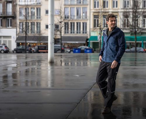 Homme en pantalon de pluie Hello Rain Budget noir en ville sous la pluie