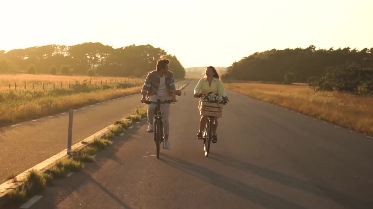 Deux cyclistes avec paniers AtranVelo sur une route de campagne au coucher du soleil