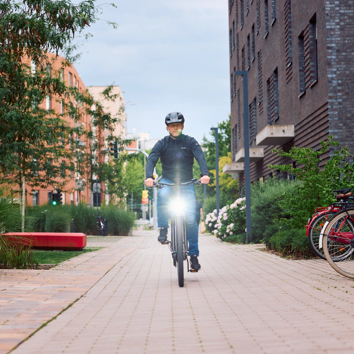Cycliste à vélo électrique sur une rue piétonne, marque Trelock